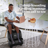 Man getting his feet warm and relax while working on laptop with the Homedics Therapist Select Foot and Calf Massage